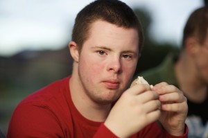 Sixteen-year-old eating a sandwich, looking at camera